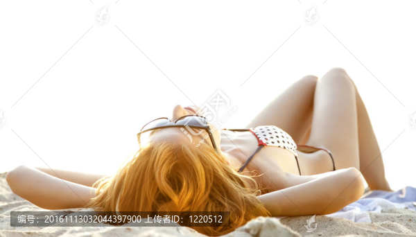在日出時(shí)在海灘美麗的紅發(fā)女孩。