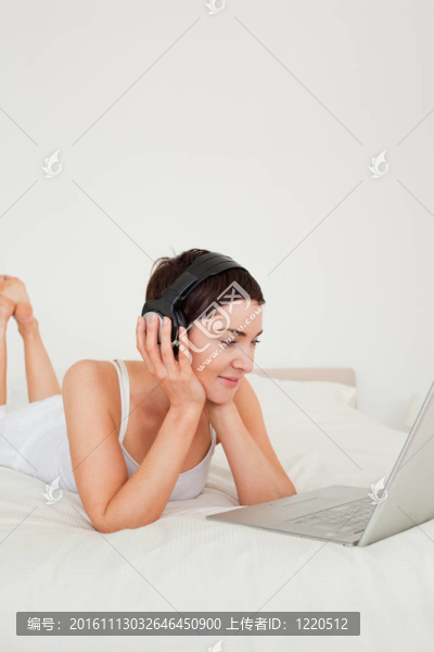 一個(gè)年輕女人用筆記本聽音樂的肖像