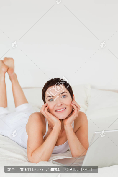 年輕的女人用筆記本電腦擺姿勢