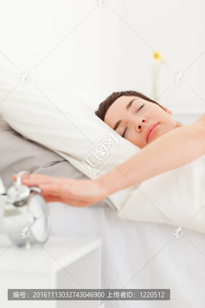 一個黑發(fā)關掉她的鬧鐘的肖像