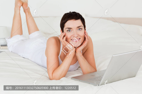 用筆記本電腦擺姿勢(shì)的女人