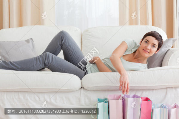 年輕的女人看著購物袋