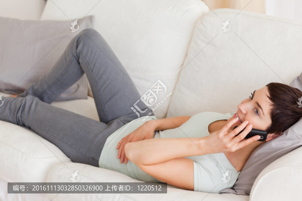 女人打電話時(shí)，平靜的躺在沙發(fā)上