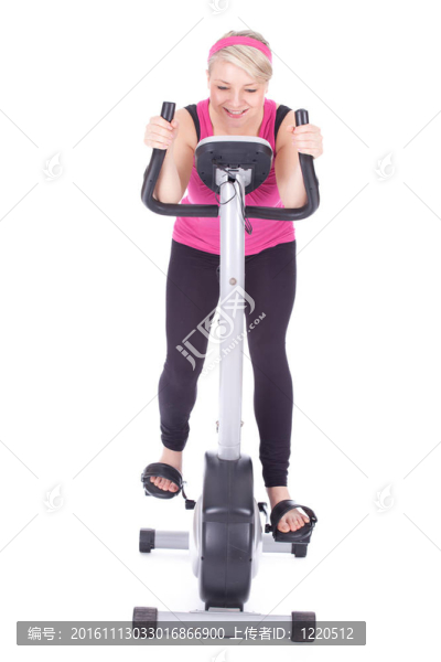 在固定訓(xùn)練自行車上鍛煉的微笑女子