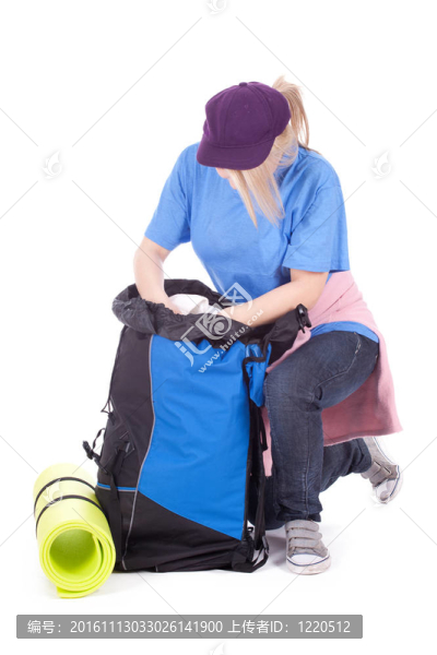 年輕女性游客在棒球帽尋找東西在背包