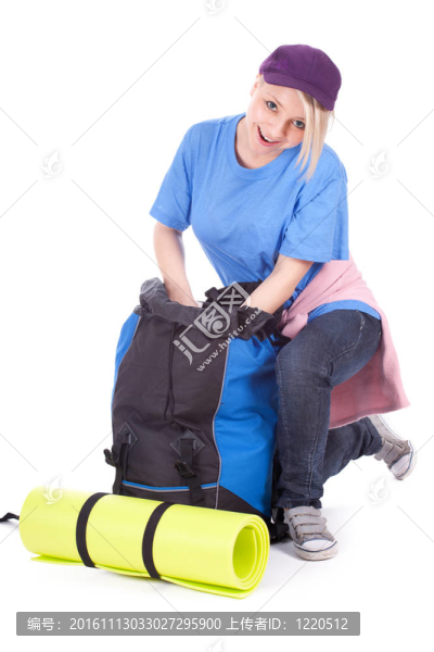 年輕女性游客在棒球帽尋找東西在背包
