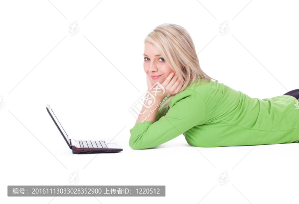 穿綠色休閑襯衫的年輕女性在筆記本電腦上工作