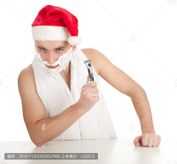 刮胡子的英俊的年輕人在紅色的Christmsa帽子泡沫和剃須刀