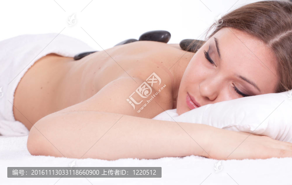 美麗的年輕女子在水療院；石頭按摩
