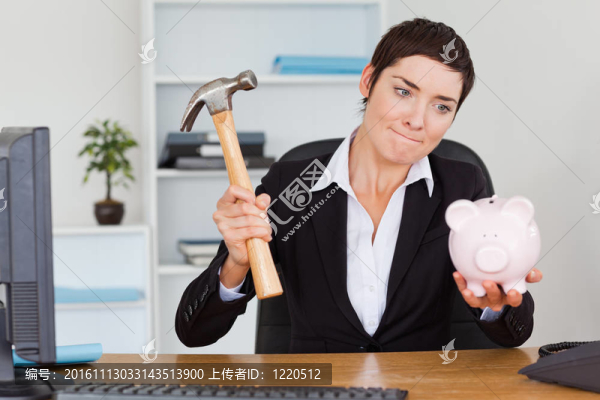 辦公室的工作人員用錘子打破撲滿
