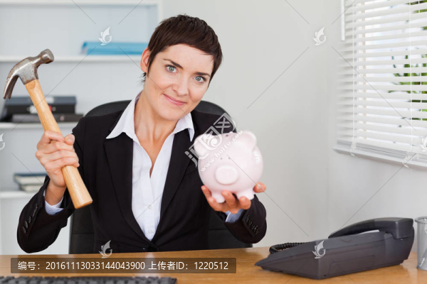 可愛的上班族用錘子打破撲滿