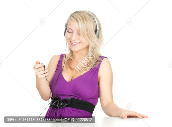 微笑的年輕女子在耳機(jī)和MP3播放器