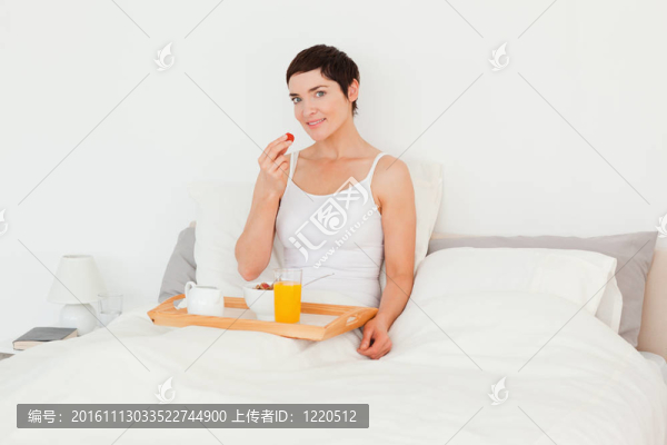 年輕的女人吃一個(gè)草莓
