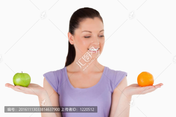 一個(gè)迷人的女人站著拿著水果的肖像