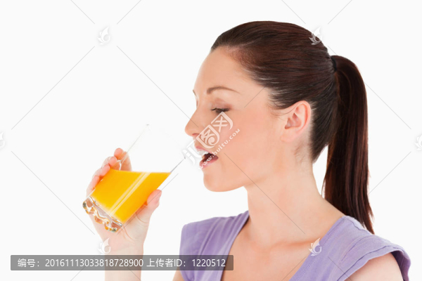 美女站著喝一杯橙汁