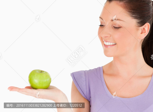迷人的女人拿著蘋果站著