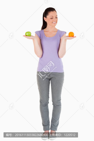 漂亮的女人站著拿著水果