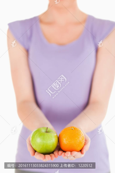 年輕女子站著拿著水果