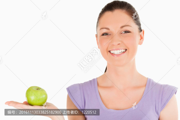 迷人的女人拿著蘋果站著