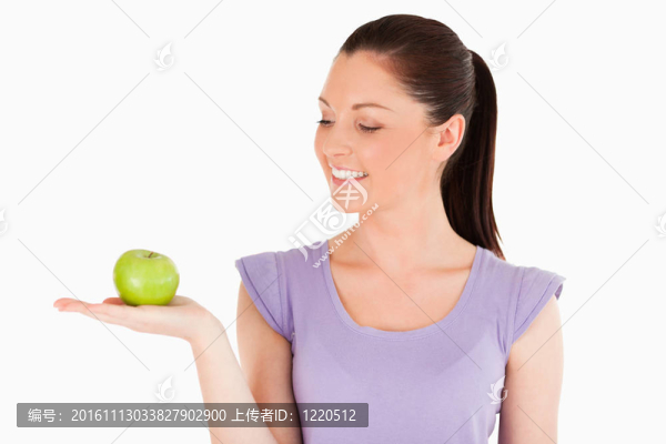 漂亮的女人拿著蘋果站著