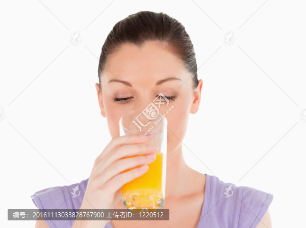 長相漂亮的女人站在白底上喝一杯橙汁