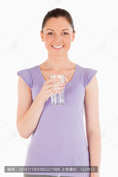 迷人的女人拿著一杯水站著