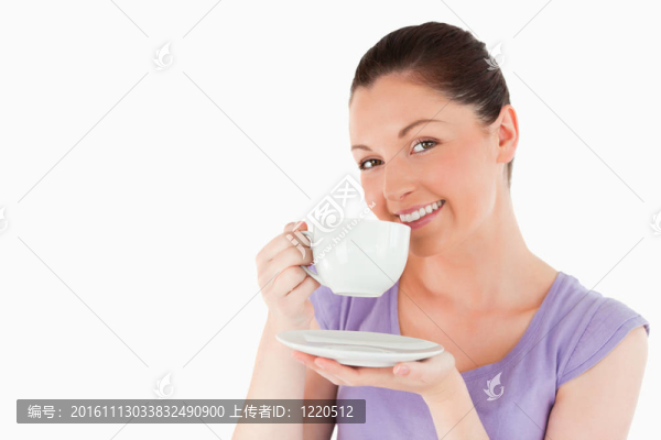 可愛(ài)的女人一邊站著一邊喝著咖啡