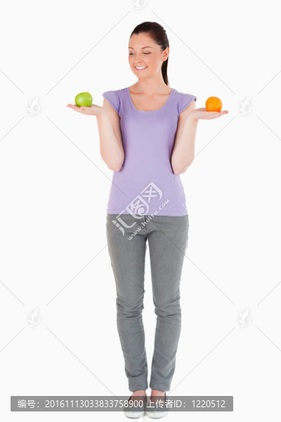迷人的女人拿著水果站著