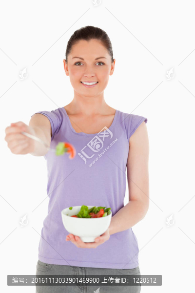 漂亮女人拿著一碗沙拉站著