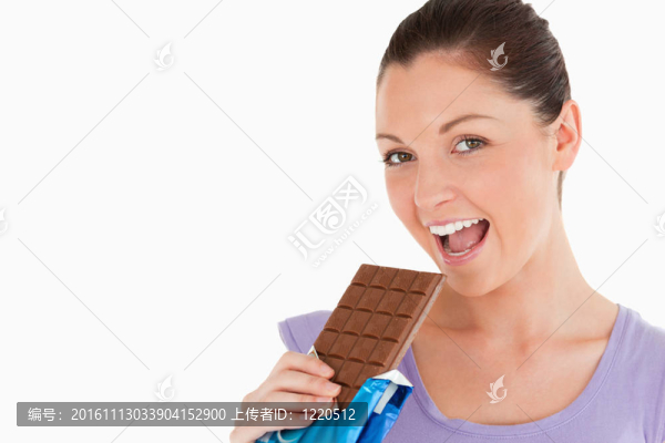 一個長相漂亮的女人站在白色背景下吃巧克力塊的肖像