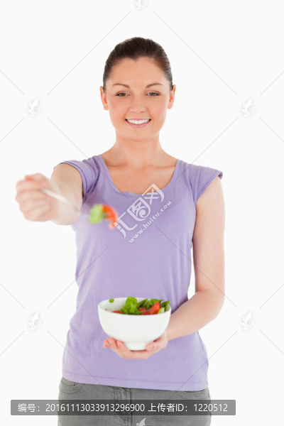 華麗女子拿著碗沙拉站著