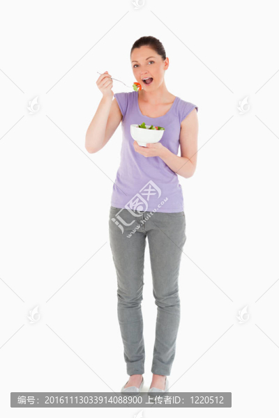 華麗女子吃碗沙拉站著