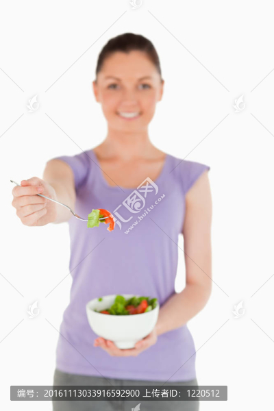 漂亮的女人拿著一碗沙拉站著