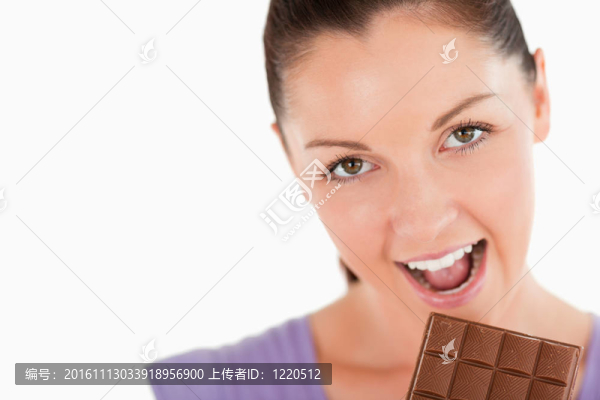 一個漂亮女人在白色背景下吃巧克力塊的肖像