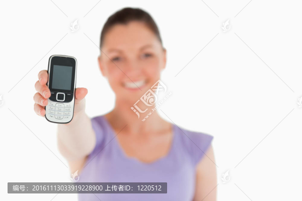 迷人的女子手持和顯示她的手機(jī)，而站