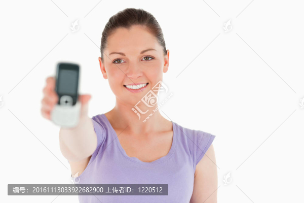 漂亮的女人持有和顯示她的手機(jī)，而站