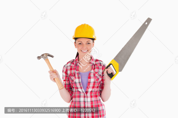 迷人的女人拿著鋸子和錘子站著