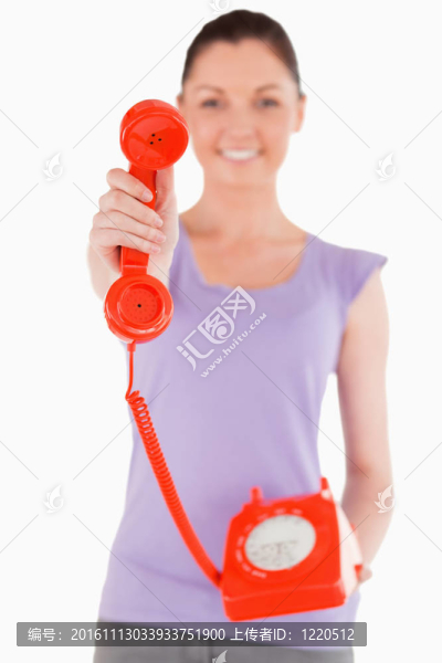 漂亮女子手持紅色電話站著