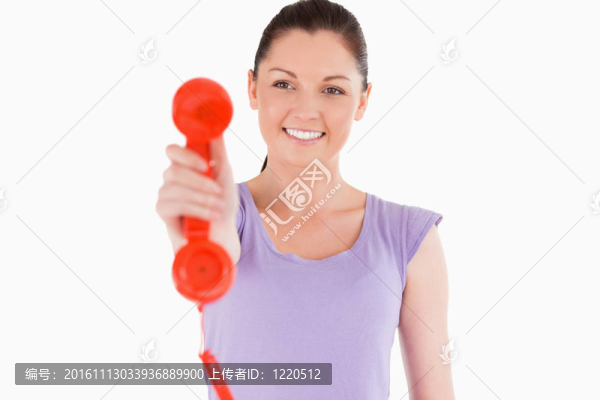 漂亮的女人站著拿著紅色電話