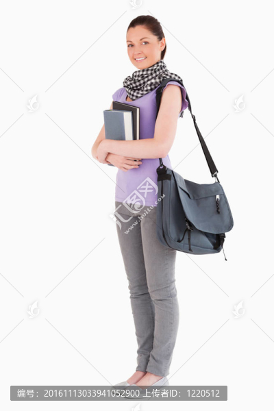 迷人的學(xué)生拿著書(shū)和她的書(shū)包站著-匯圖網(wǎng) www.fosd68.com 迷人的學(xué)生拿著書(shū)和她的書(shū)包站著
