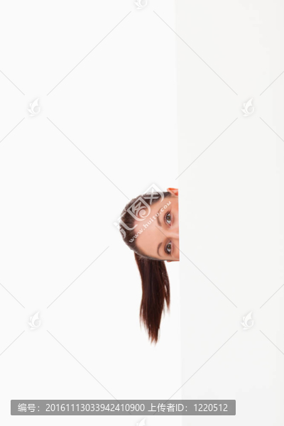 可愛的女人站在廣告牌后面站著