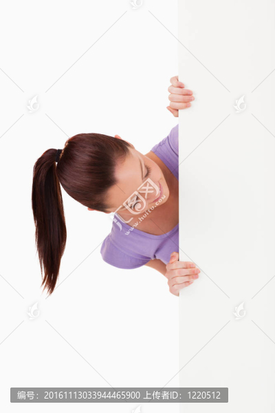 一個可愛的女人站在白色背景上看廣告牌的肖像