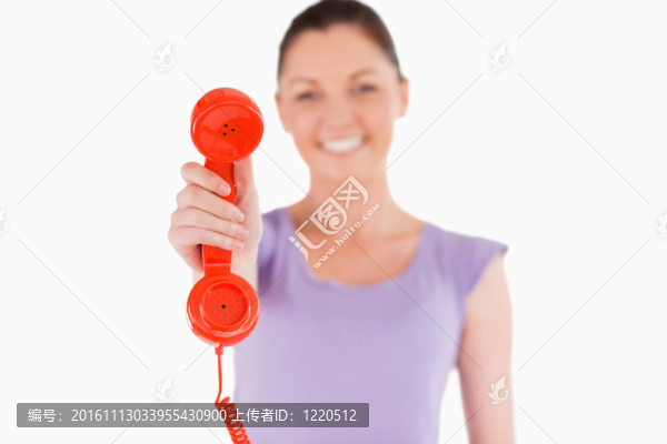 美女站著拿著紅色電話