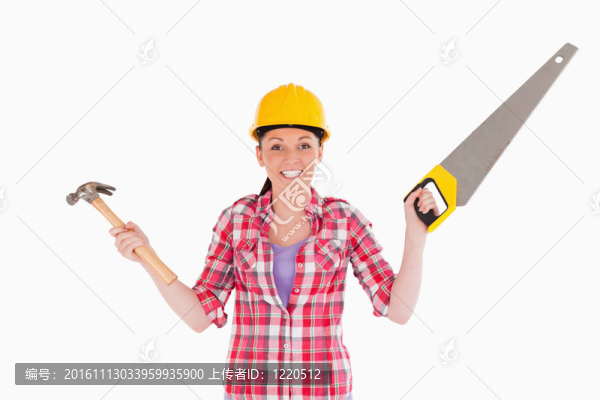 漂亮的女人拿著鋸子和錘子站著