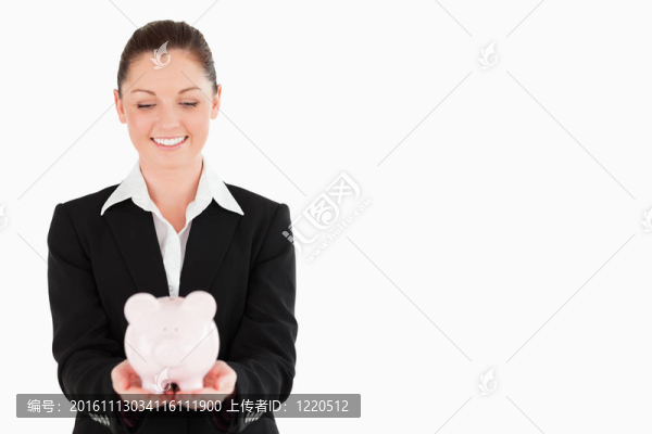 漂亮的女人抱著粉紅色的存錢罐
