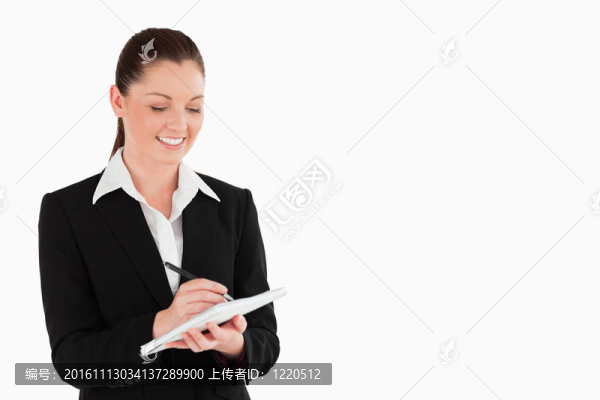 一個(gè)迷人的女人在西裝寫(xiě)在筆記本上的肖像