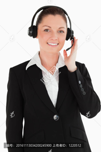 一個漂亮的女人穿西裝，用耳機和姿勢，而站在白色背景