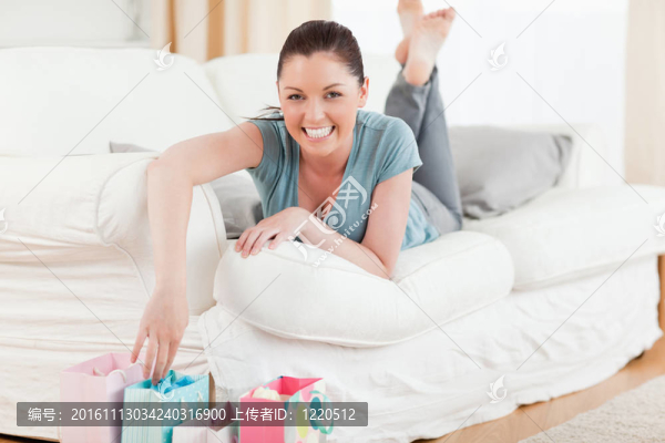 漂亮的女人在客廳的沙發(fā)上摸她的購物袋