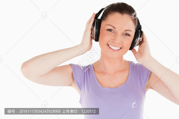 可愛的女人擺著耳機(jī)站著