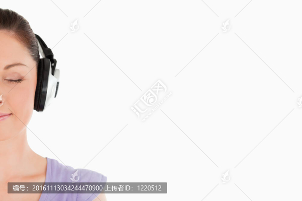 站在白色背景上的一個戴著耳機的漂亮女人的肖像